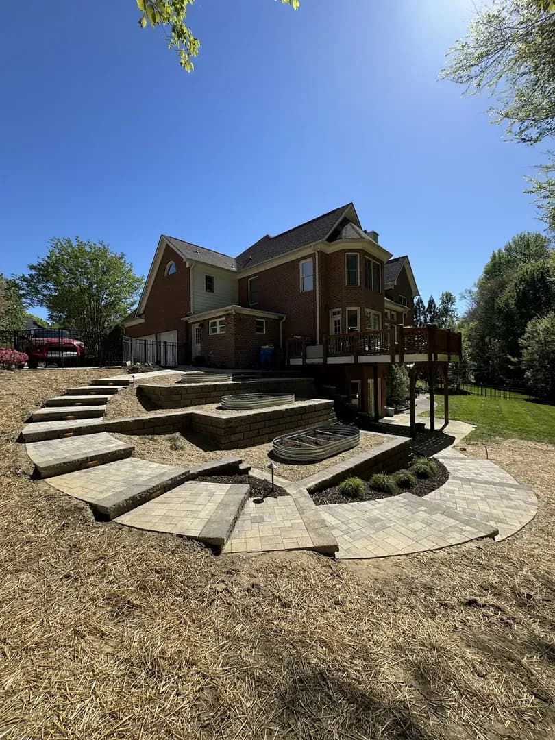 Green Sod Backyard with Privacy Wall by Alex's Lawnscape in Charlotte NC — Expansive green sodded backyard with brick privacy wall, pool area, and evergreen backdrop — clean, finished result showing the full scope of landscape installation