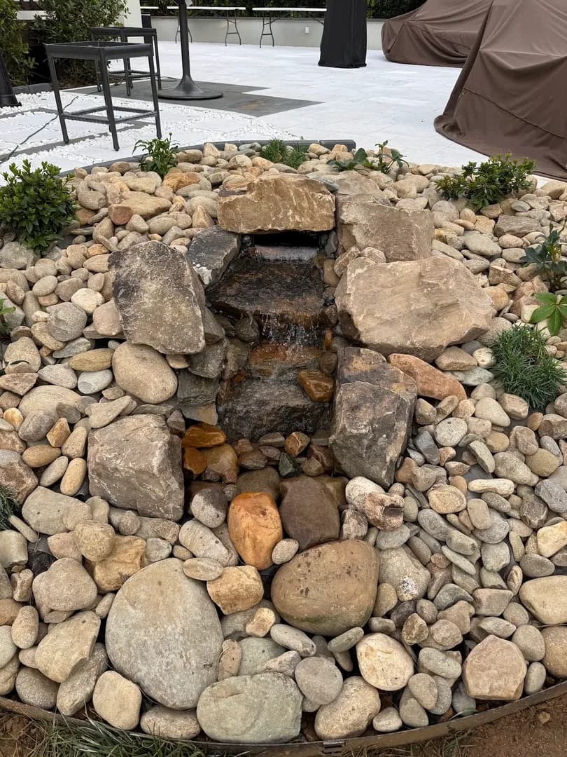 Custom She-Shed with Landscaping by Alex's Lawnscape in Charlotte NC — Attractive green board-and-batten outbuilding with covered porch, French doors, wooden steps, and pine straw landscaping