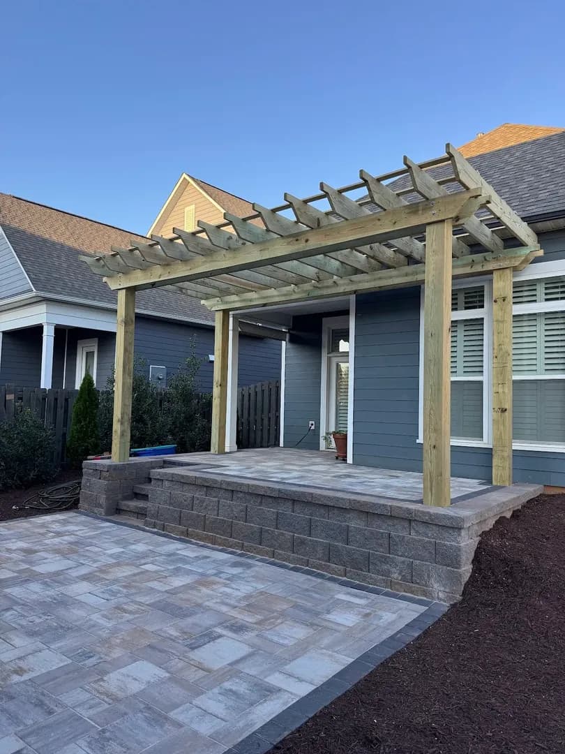 Outdoor Stone Fireplace by Alex's Lawnscape in Charlotte NC — Custom natural stone outdoor fireplace with rustic wood mantel, firebrick interior, and stone hearth under a covered patio