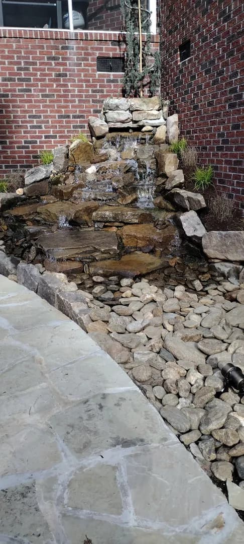 Raised Patio Entry at French Doors by Alex's Lawnscape in Charlotte NC — Raised paver patio with retaining wall block base at a brick home with French doors