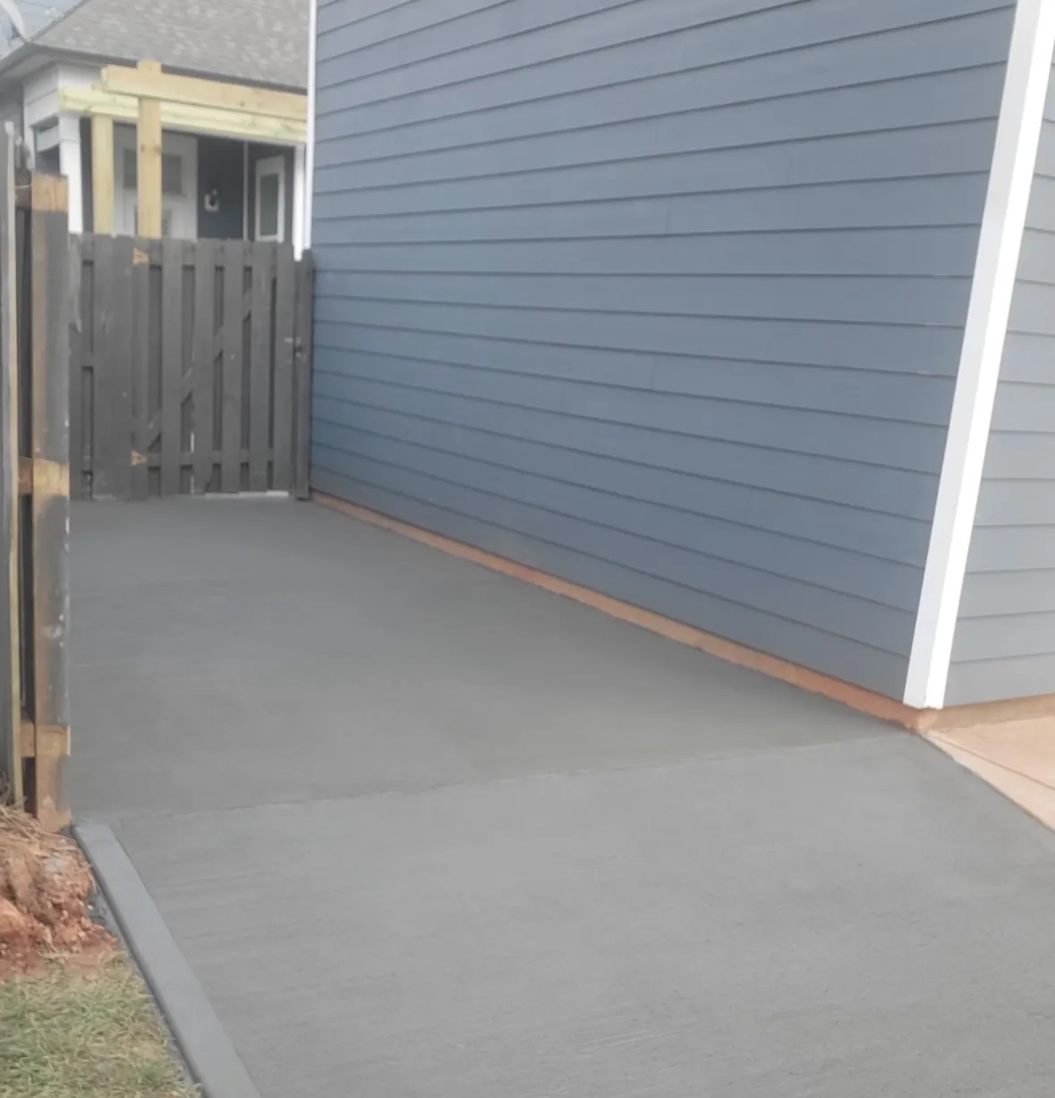 Residential Concrete Walkway by Alex's Lawnscape in Charlotte NC — Fresh concrete walkway pour along the side of a residential home with smooth broom finish and clean formed edges